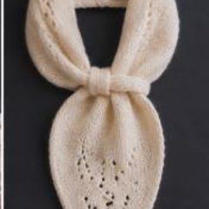 May include: A cream-colored knitted scarf featuring a delicate lace pattern with small eyelet holes. The scarf is shaped like a pointed bandana and includes a matching knitted loop to secure the ends together in a neat, folded configuration.