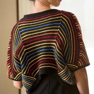 Puede incluir: Un poncho tejido multicolor con rayas horizontales rojas, naranjas, amarillas, azules y negras. El poncho tiene un cuello y bordes de manga negros. La prenda está hecha de un hilo suave y texturizado.