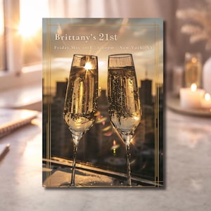 Puede incluir: Tarjeta de invitación rectangular con el texto "Brittany's 21st" en letras doradas. Dos copas de champán llenas de líquido burbujeante en primer plano, con un paisaje urbano y una puesta de sol al fondo. La tarjeta tiene un borde dorado.