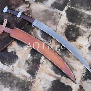 May include: A curved blade sword with a brown wooden handle and a tan leather sheath. The blade is silver and the sheath is stitched with a darker thread. The text "AO Forge" is visible on the sheath.