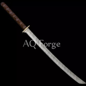 May include: A katana-style sword with a curved, silver blade and a dark brown handle. The handle has a textured appearance. The sword features a gold-colored handguard. The text "AQ Forge" is visible on the blade.