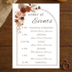May include: A wedding event schedule printed on white cardstock. The design features a floral arrangement in shades of brown and cream. The text "order of Events" is at the top, with event details listed below, including times and locations.
