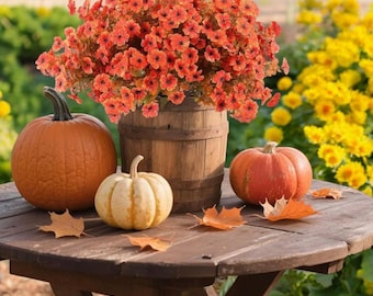 May include: A rustic wooden table displays a fall harvest scene. A wooden barrel holds orange flowers, surrounded by pumpkins in various sizes and colors. Scattered leaves add to the autumnal theme, with yellow flowers in the background.
