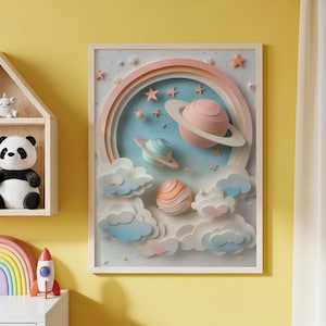 Puede incluir: Una obra de arte en papel 3D enmarcada con un tema espacial. La obra de arte incluye planetas con anillos, estrellas y nubes esponjosas en colores pastel. Los planetas son rosas, azules y naranjas, sobre un fondo azul claro.