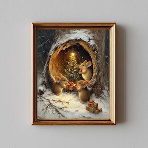 Puede incluir: Una impresión enmarcada muestra tres ratones marrones reunidos alrededor de un árbol de Navidad dentro de un hueco de árbol. Los ratones están rodeados de nieve y regalos, con una luz cálida que ilumina la escena. El marco es dorado.