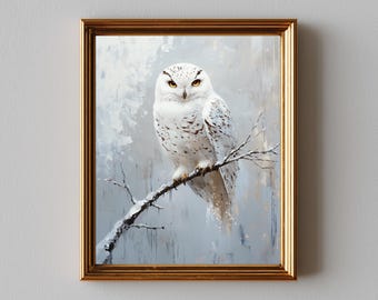 May include: A framed painting of a snowy owl perched on a branch. The owl has white feathers with black markings and yellow eyes. The artwork is set against a muted gray and blue background, and the frame is gold.