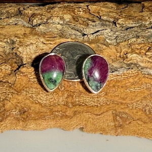 May include: A pair of teardrop-shaped earrings with green and pink gemstones set in silver.