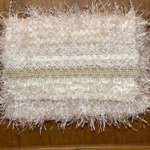 Creamy Frill very soft knitted iridescent ivory ribbon yarn with ivory eyelash yarn throughout. image 1