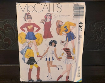 May include: Vintage McCall's sewing pattern featuring illustrations of cheerleaders and majorettes in various outfits. The pattern includes a size 10. The cover art showcases a retro design with the McCall's logo and pattern number 4341.