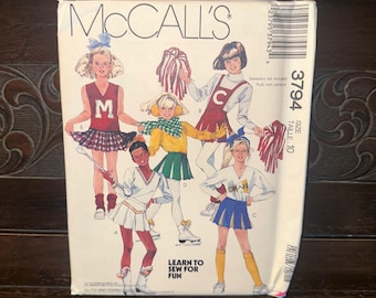 May include: Vintage McCall's sewing pattern featuring illustrations of cheerleaders in various outfits. The pattern includes designs for pleated skirts, tops, and accessories. The cover has the text "McCall's", pattern number 3794, and "Learn to Sew for Fun".