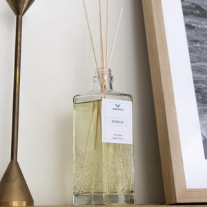 Op de afbeelding: Een witte keramische mok met een zwart handvat en de tekst "But First, Coffee" in een zwarte, handgeschreven lettertype. De mok staat op een wit oppervlak.