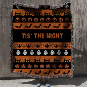 Halloween themed Throw Blanket with ghosts, pumpkins, bats, black cats and spiders graphics on a black and orange striped background