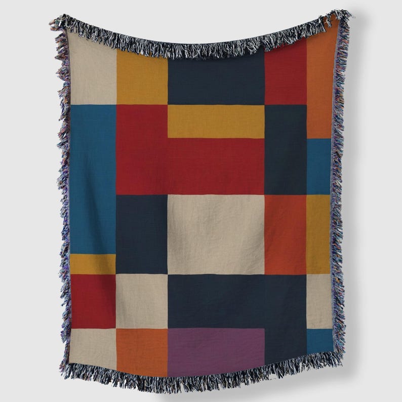 May include: A colorful throw blanket with a geometric design. The blanket features a patchwork of rectangles in various colors, including red, blue, yellow, orange, and beige. The edges are finished with a fringe.