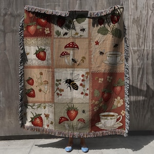 woven throw blanket featuring an enchanting patchwork of strawberries, honeybees, mushrooms, flowers, and tea cups