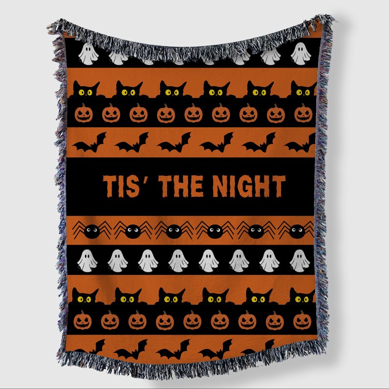 May include: Halloween throw blanket with orange and black stripes. Features repeating patterns of black cats, jack-o'-lanterns, bats, spiders, and ghosts. The phrase "TIS' THE NIGHT" is displayed in bold white letters.