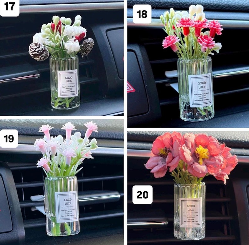 May include: Four car air vent diffusers with small glass vases filled with colorful artificial flowers. Each vase has a label that reads "GOOD LUCK". The flowers are in shades of pink, red, white, and yellow.