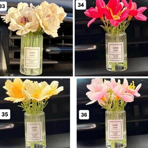 May include: A collection of small glass vases, each filled with artificial flowers. The flowers vary in color, including cream, red, yellow, and pink. Each vase has a label that reads "GOOD LUCK".