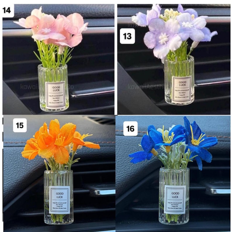 May include: Four small glass vases, each containing a different color of artificial flowers. The flowers are pink, purple, orange, and blue. Each vase has a label that says "GOOD LUCK". The vases are placed in a car's air vent.