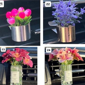 May include: A collection of four car air vent decorations. The first features pink tulips in a silver metal pot. The second has purple flowers in a gold pot. The third and fourth have flowers in a glass vase with "GOOD LUCK" text.