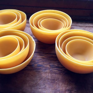 Peut inclure: Quatre ensembles de bols emboîtés en céramique jaune. Chaque ensemble comprend trois bols de tailles différentes, le plus petit étant à l'intérieur du plus grand.