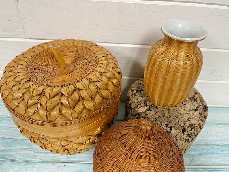 May include: Three woven baskets, one shaped like an apple with a lid, one a tall vase, and one a round, dome-shaped basket.