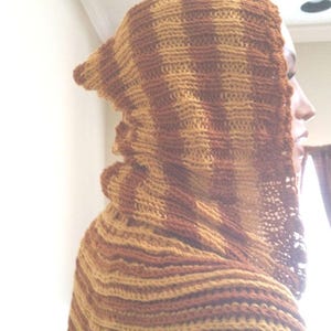 May include: A brown and tan striped hooded scarf made of crocheted yarn.