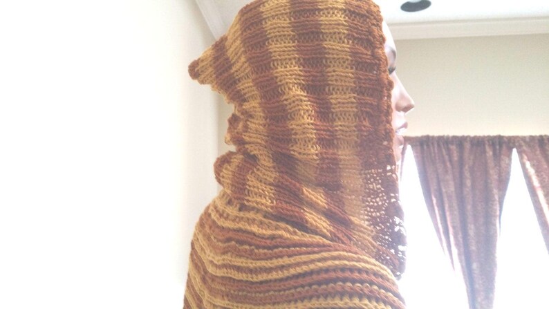 May include: A brown and tan striped hooded scarf made of crocheted yarn.