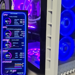 May include: A computer case with a side panel displaying internal component data. The screen shows CPU, GPU, RAM, and storage information, with temperatures in Celsius. The case has blue and purple internal lighting.