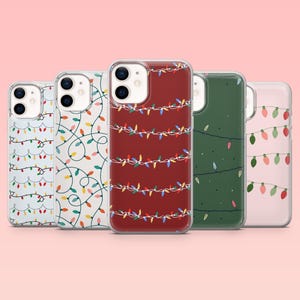 Peut inclure: Cinq coques de téléphone avec des motifs de guirlandes lumineuses de Noël. Les coques présentent des fonds transparents, rouges, verts et blancs avec des guirlandes colorées. Les coques sont en matériau transparent et protecteur.