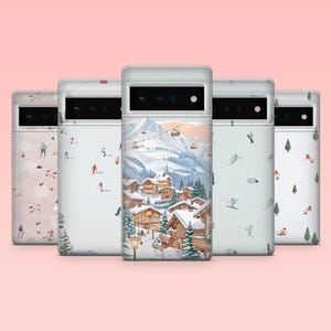 May include: A collection of five phone cases with winter-themed designs. The cases feature illustrations of skiers, snowy landscapes, and mountain villages. The cases are white with various colorful illustrations.