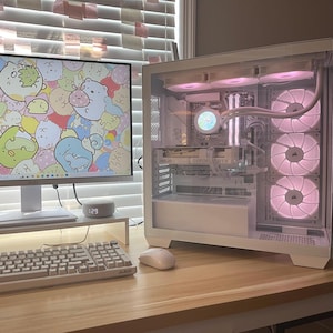 May include: A white computer setup featuring a desktop computer with a clear side panel, a monitor displaying a cartoon background, a keyboard, and a mouse. The computer's internal components are illuminated with pink lights.
