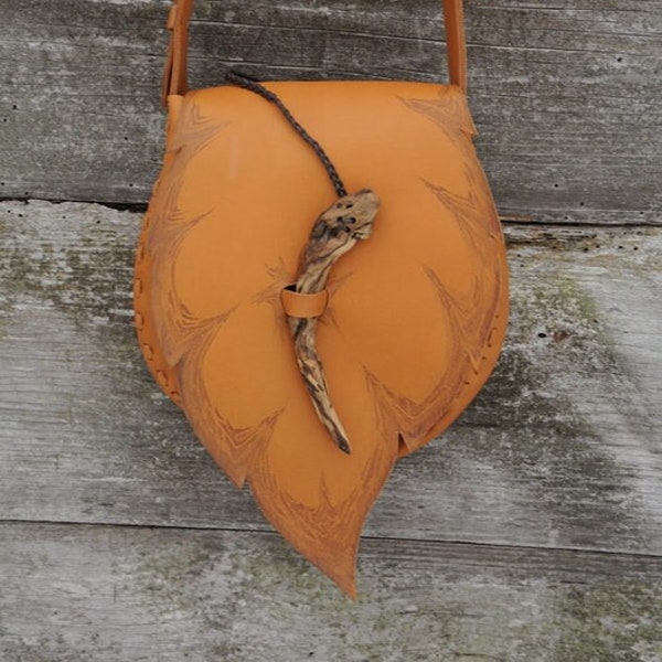 Sac fait main en cuir naturel, décoré d'un motif de feuilles et d'une épingle en bois.