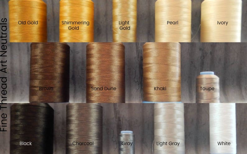 以下が含まれることがあります： Old Gold、Brown、Whiteなどの色でラベル付けされた、ニュートラルな色調の糸巻きのコレクション。画像には、輝くゴールド、カーキ、ライトグレーなど、さまざまな色合いが表示されています。「Fine Thread Art Neutrals」というテキストが表示されています。