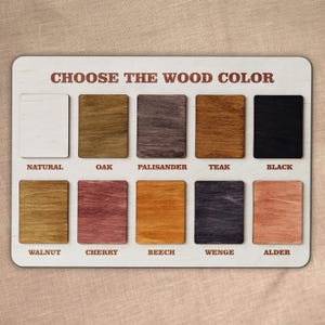 May include: A wooden color chart with ten wood stain samples. The chart reads "CHOOSE THE WOOD COLOR" in brown text. The wood stain colors include natural, oak, palisander, teak, black, walnut, cherry, beech, wenge, and alder.