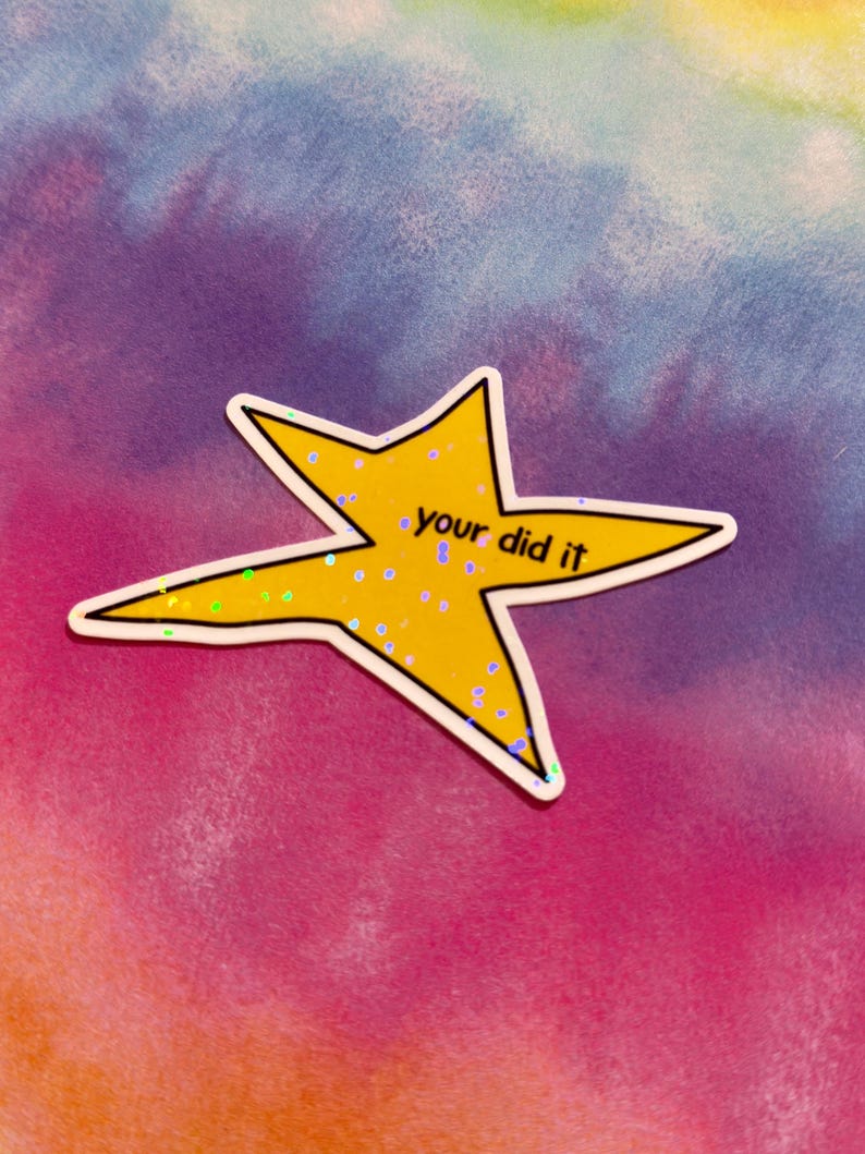 以下が含まれることがあります： 「your did it」という手書きフォントのテキストが入った、黄色の星型のステッカー。ステッカーには白い縁取りと虹色のグリッターアクセントが付いています。背景はピンク、紫、青、黄色のタイダイ模様です。