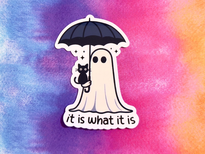 May include: A die-cut sticker featuring a cartoon ghost holding a black umbrella and a black cat. The text "it is what it is" is at the bottom. The background is a watercolor wash of purple, pink, and orange.