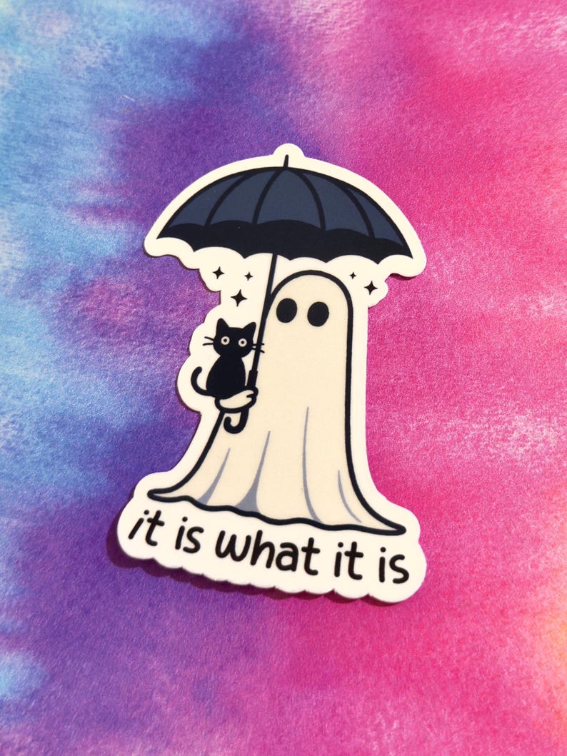 May include: A sticker featuring a cartoon ghost holding a black umbrella with a black cat. The ghost has two black eyes and is wearing a white sheet. The text "it is what it is" is at the bottom.