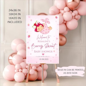 May include: A pink baby shower sign with the text "Welcome to Rosaline's Berry Sweet Baby Shower" and the date 10-08-2025. The sign features a cartoon baby in a pink blanket and strawberry accents. The sign is on a gold easel.