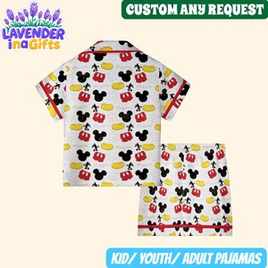 A white and yellow Mickey Mouse-themed pajama set, including a shirt and shorts, is shown in the image.
