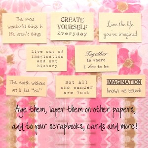 May include: A collection of cream-colored rectangular paper tags with inspirational quotes in black text. The tags are arranged on a pink floral patterned background. The text includes phrases like "Create Yourself Everyday" and "Imagination knows no bounds."