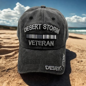 Könnte beinhalten: Anthrazitfarbene Baseballkappe mit weiß gesticktem Schriftzug "DESERT STORM VETERAN". Die Kappe hat einen gebogenen Schirm und einen Used-Look, mit "DESERT STORM" auf der Seite gestickt.