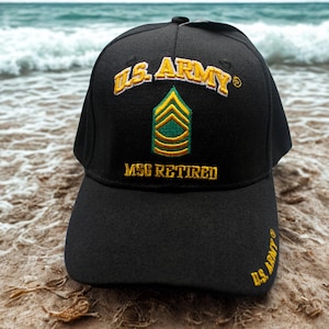 Puede incluir: Gorra de béisbol negra con texto bordado en dorado «U.S. ARMY» y «MSG RETIRED». La gorra presenta una insignia verde y dorada. Las palabras «U.S. ARMY» también están bordadas en el lateral.