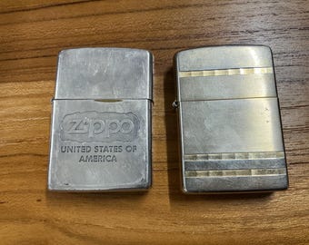 Lote de 2 encendedores Zippo vintage: uno cromado patriótico estadounidense de 1994 y otro horizontal con franja dorada de 2005. Auténticos, fabricados en Bradford, Pensilvania, EE. UU.