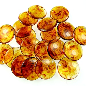 May include: A collection of round, amber-coloured, translucent beads with swirling patterns. The beads have a smooth, glossy finish and are perfect for jewellery making or crafting.