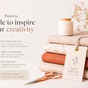 May include: A stack of folded fabric in beige, floral, and terracotta colors, topped with a spool of white thread and a tag labeled Cheri Demeter Patterns. Beside the fabric are copper-colored scissors and text about sewing patterns.