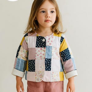 May include: A long-sleeve jacket featuring a patchwork design with various floral, striped, and solid-colored fabric squares in shades of yellow, blue, pink, and white. The jacket has a round neckline, three white buttons, and folded cuffs.