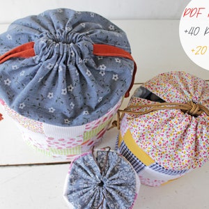 May include: Three drawstring bags made of patchwork fabric. The bags are in various sizes and feature different floral patterns. The largest bag is blue with white flowers, the medium bag is white with pink and yellow flowers, and the smallest bag is blue with white flowers. The bags are all tied with a drawstring.