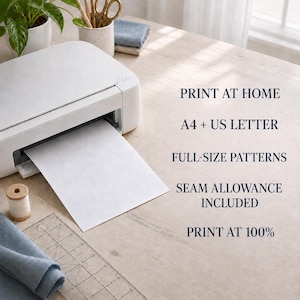 May include: A white printer with a sheet of paper emerging from the slot. Text on the right reads: PRINT AT HOME, A4 + US LETTER, FULL-SIZE PATTERNS, SEAM ALLOWANCE INCLUDED, PRINT AT 100%. A wooden spool of thread and a clear plastic ruler are visible.