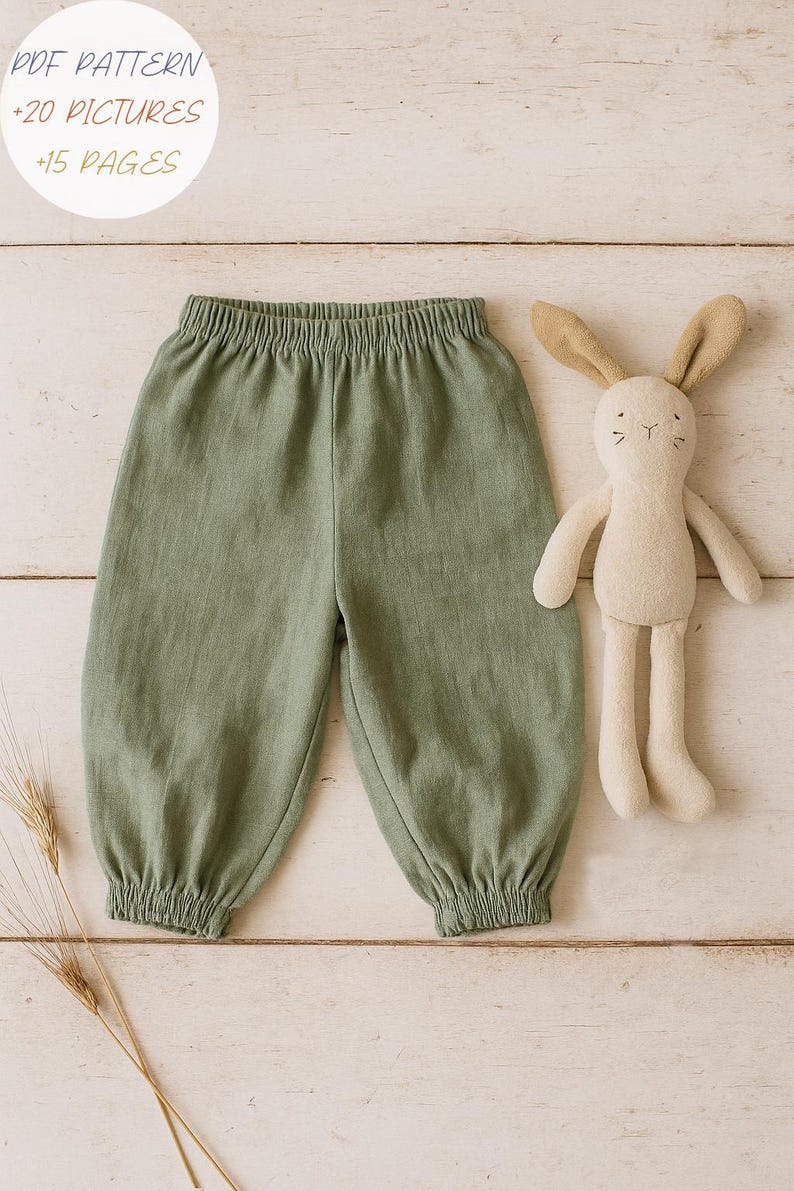May include: Sage green pants with an elastic waistband and gathered elastic cuffs, accompanied by a beige plush rabbit toy. The image includes text that reads: PDF PATTERN +20 PICTURES +15 PAGES.