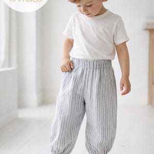 May include: A PDF pattern document featuring 15 pages and 20 pictures for sewing pants. The pants are light gray with vertical white stripes, featuring an elastic waistband and elasticized cuffs at the ankles, paired with a plain white t-shirt.